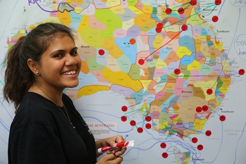 Students standing in front of map of Australia with locator dots stuck to it. 