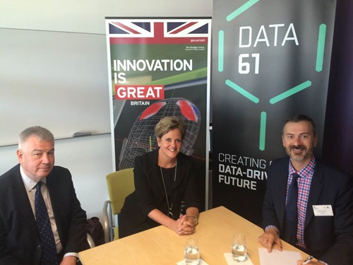 Team from Data61 sitting around a table with bars in background.
