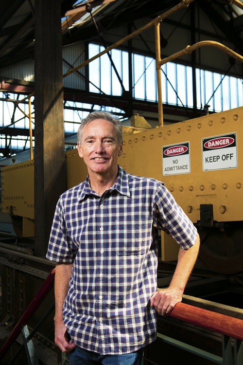 Mr Bill Bartee standing in front of wharehouse equipment.