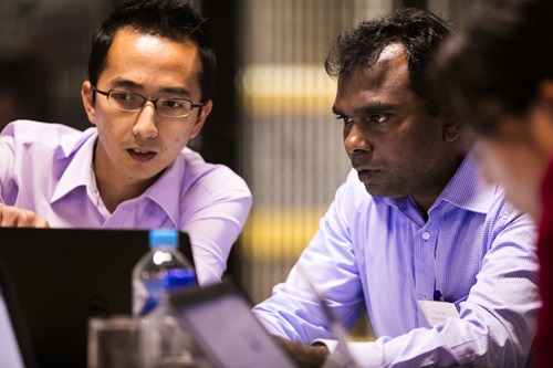 Two people having discussion in front of a laptop. 