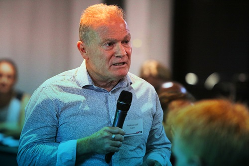Professor Jeff Hughes from Curtin University holding a microphone