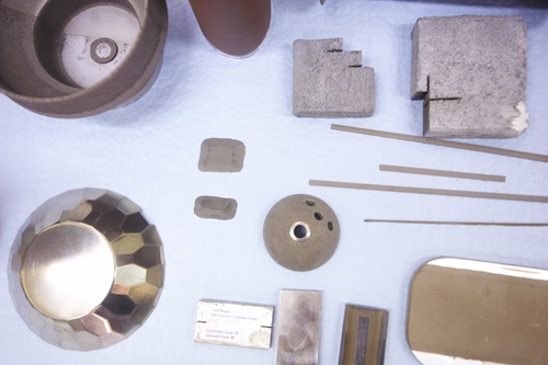 A variety of 3D printed objects arranged on a table top.