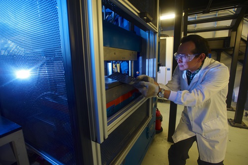 Scientist working with polymer extrusion equipment.