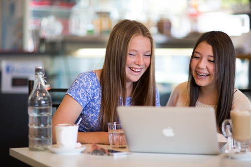 Two students working together on a laptop.