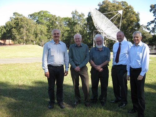 CSIRO's WLAN team standing on the lawn in front of small radio telescope.
