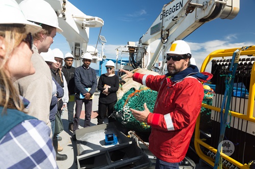 Students being instructed by teachers on the deck of the RV Investigator. 