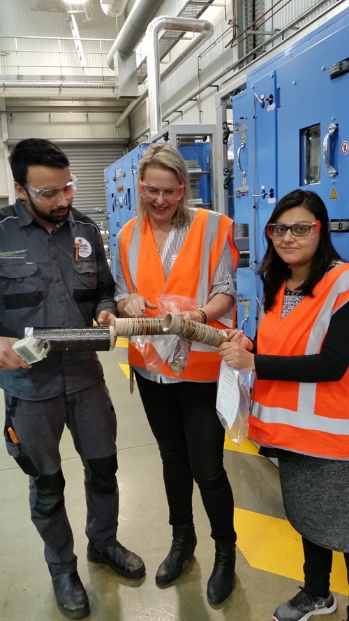 Researchers in high vis vests looking at carbon fibre.