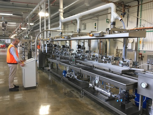 Person standing at control panel for the machinery that allow carbon fibre to be produced from scratch.