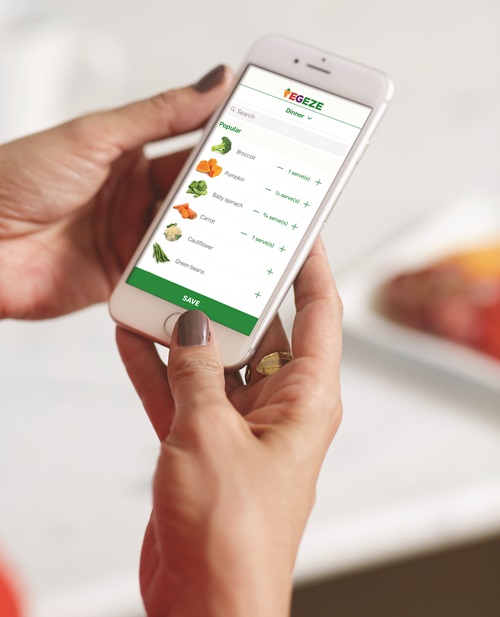 Hands holding a smartp[hone with the VegEze app open on the screen. 