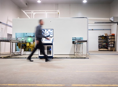 Blurred image of a person walking through a lab.
