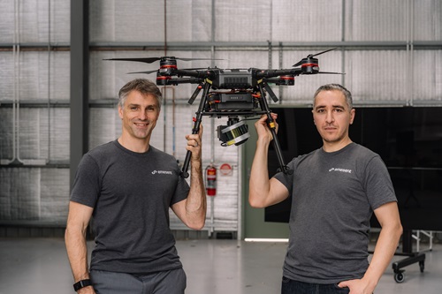 Emesent co-founders Stefan Hrabar and Farid Kendoul holding up a drone between them. 