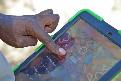 A hand is shown tapping an app