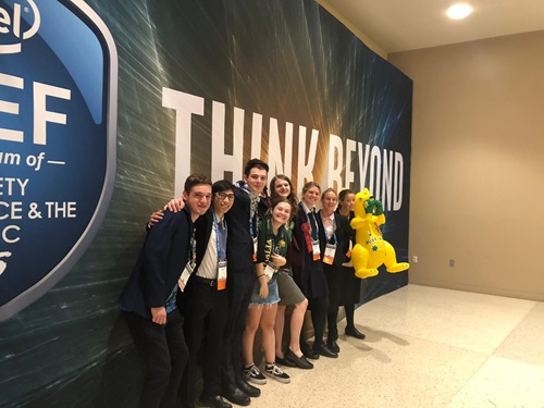 Students standing in front of the ISEF banner wall at the International Science and Engineering Fair.