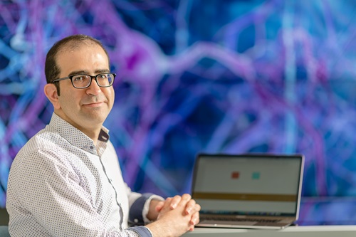 Scientist sits next to laptop
