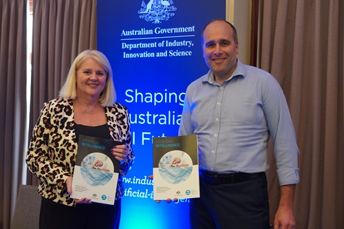 Karen Andrews and Stefan Hajkowicz holding a copy of the AI roadmap report.