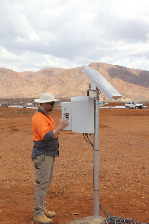 David Macedo checking SENSEI monitoring equipment from ground level. 