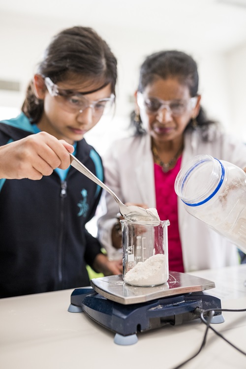 A student and STEM professional conduct an experiment