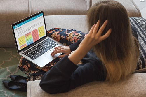Person sitting on a couch working on a laptop.