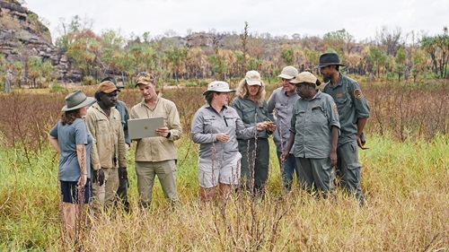 Group of people standing in grass on a floodplain. 