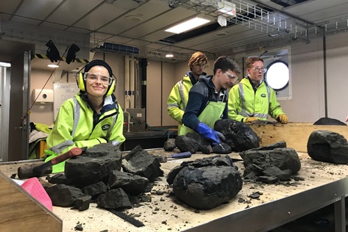 People at a work table processing rock samples. 