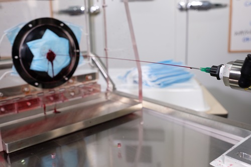 A stream of red liquid is fired at a mask