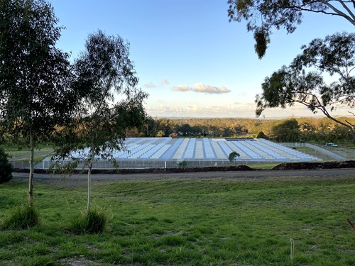 Medicinal cannabis cultivation facility in the ackground with grass and trees in the foreground. 
