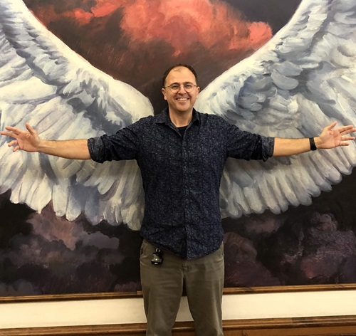 Scientist stands in front of mural