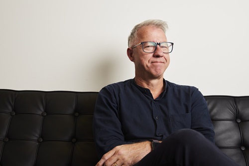 Investor sits on a black couch