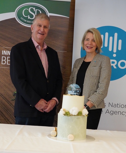 Two people beside a cake