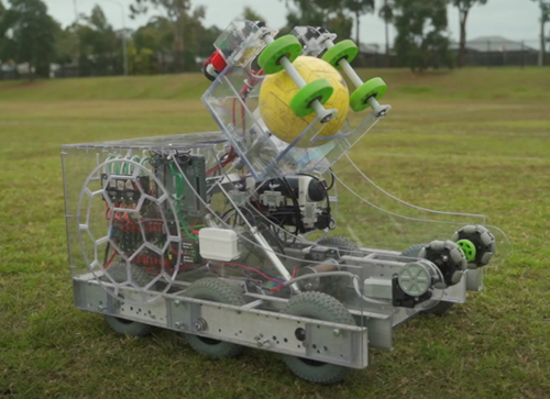 A robot on wheels holds a soccer ball