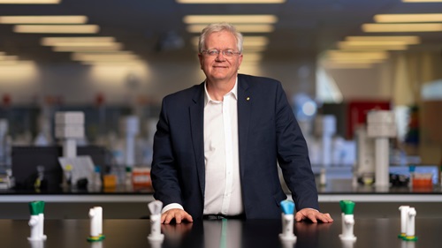 A scientist stands at a table