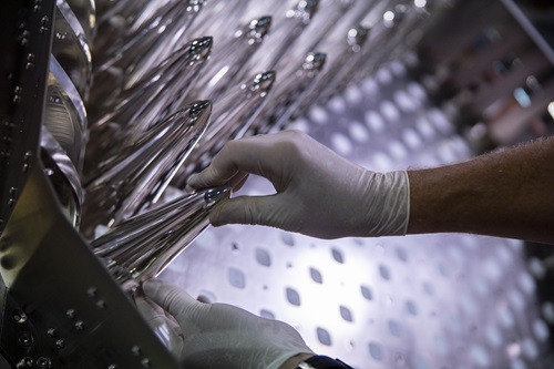 Close up of gloved hands puting together a new phased array.