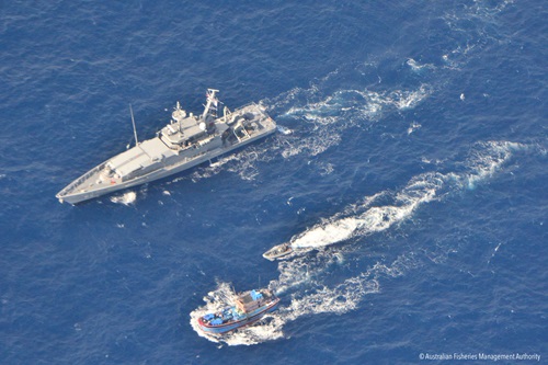 An Australian patrol boat and its tender travel beside an illegal fishing boat