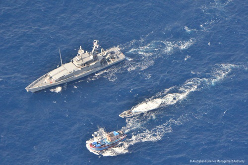 An Australian patrol boat and its tender travel beside an illegal fishing boat