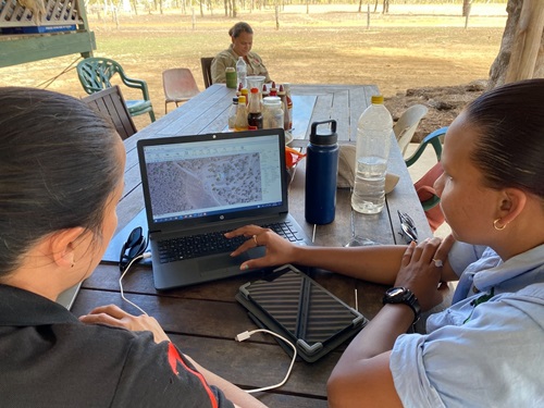 Two people looking at a laptop screen. 