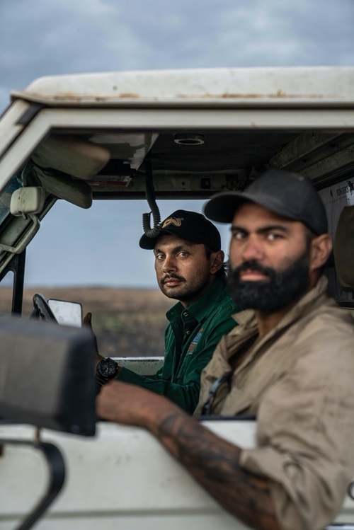 Two people looking out the window of a vehicle. 