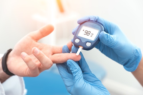 Doctor checking blood sugar level with glucometer.