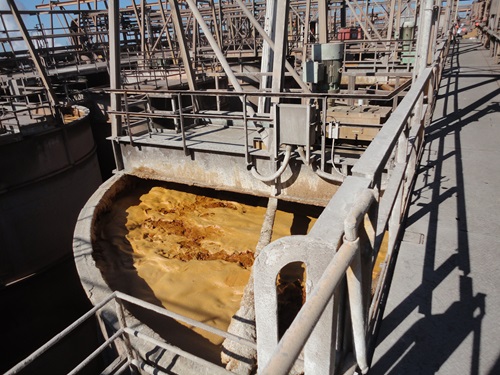 Industrial tank filled with swirling brown frothy liquid