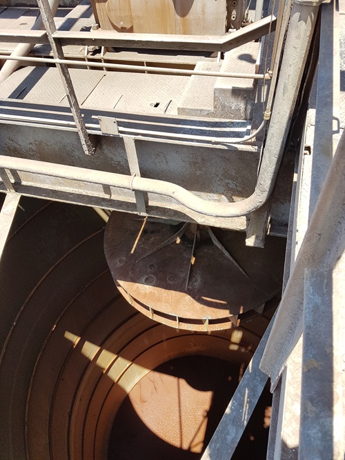 View inside an empty industrial mixing tank showing SWIRFLOW’s round mixer head at top
