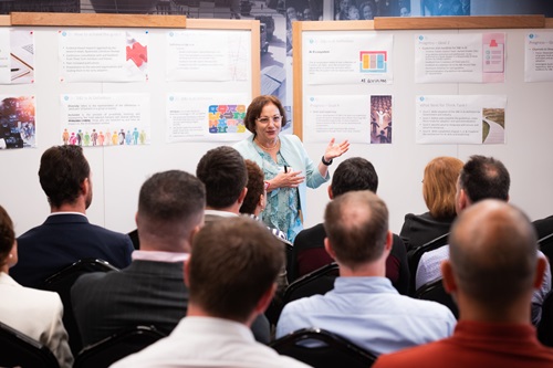 Woman presenting in front of a crowd