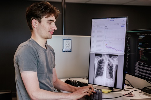 Scientists Dr Aaron Nicholson looking at a computer screen with an x-ray on it. 