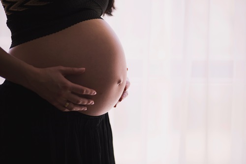 Pregnant woman holding stomach.