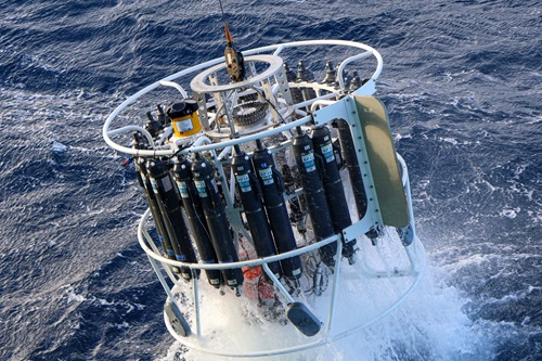 CTD rosette emerges from the deep with water samples photo.