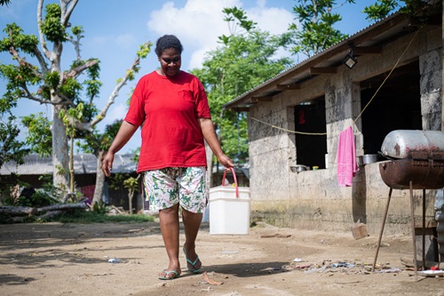 Woman carrying a pail of water in Vanuatu.