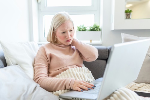 Blond lady sitting on a sofa with a latptop