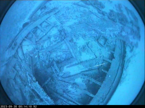 An underwater image of a shipwreck on the seafloor.