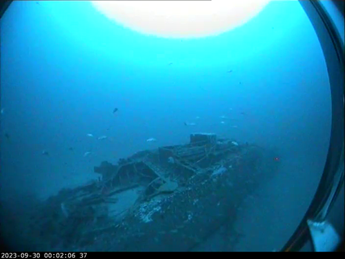 An underwater photo of a shipwreck on the seafloor.