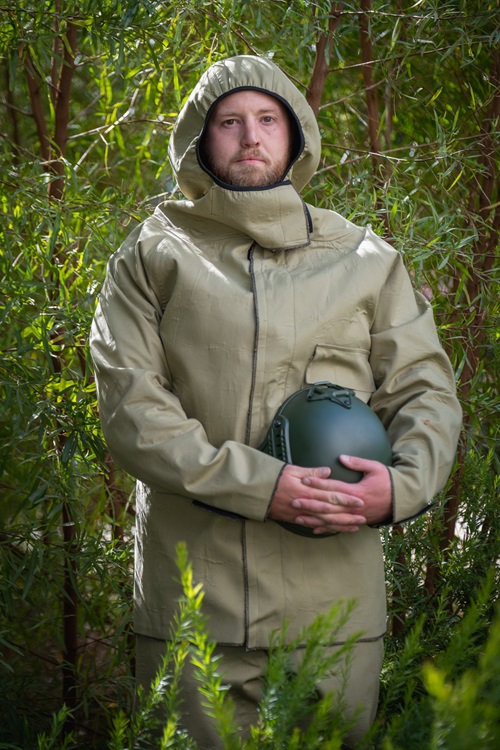 Person wearing the prototype uniform, holding a helmet. 
