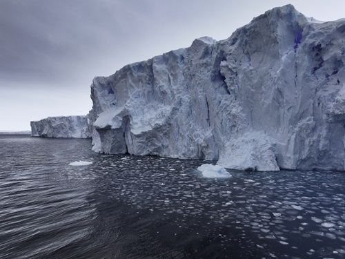 Image looking up at large cliff face of Denman Glacier.