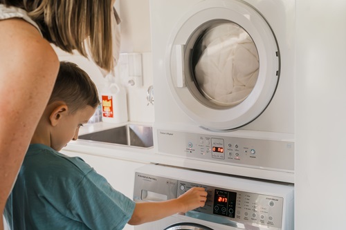 Mother and child using washing machine